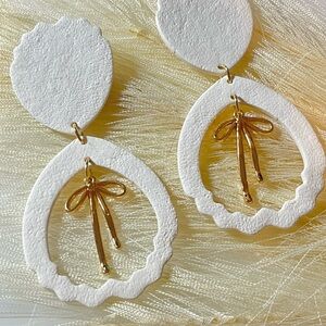 White Textured Dangle Earrings with Gold Bow Accent